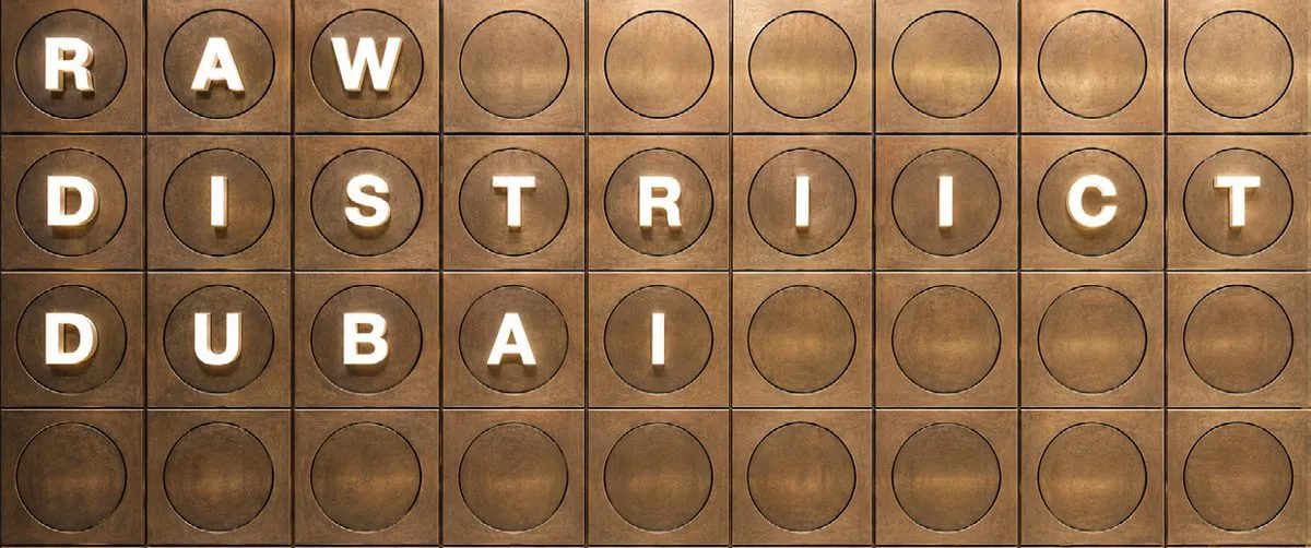 Branded In Brass — aged brass tiles stamped with the RAW District identity